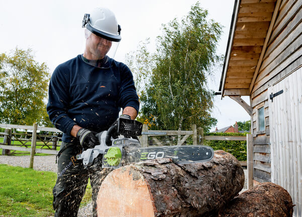 Man operating battery chainsaw